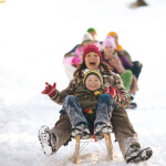 Family having a blast on a sled.