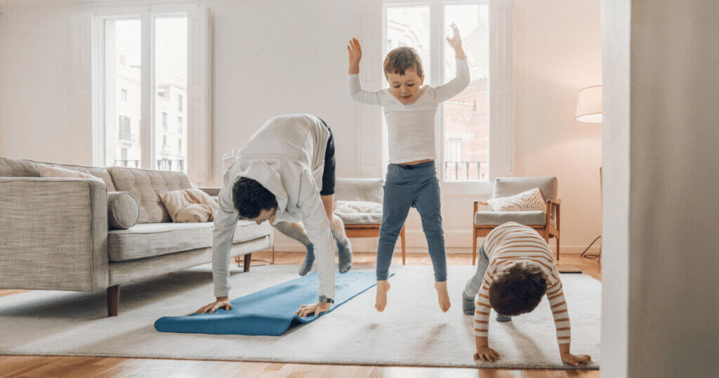 Parents and kids exercising together at home and having fun.