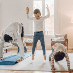 Parents and kids exercising together at home and having fun.
