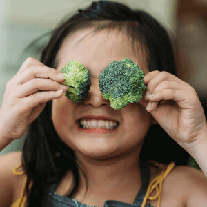 Kid with broccoli, news thumb.