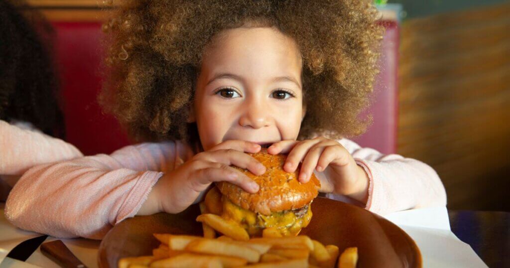 Happy kid child eating hamburger smiling