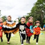 Kids in their Halloween costumes, running in an field