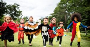 Kids in their Halloween costumes, running in an field