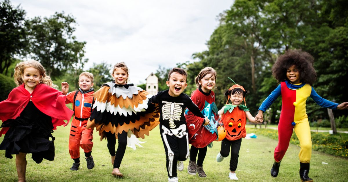 Kids in their Halloween costumes, running in an field