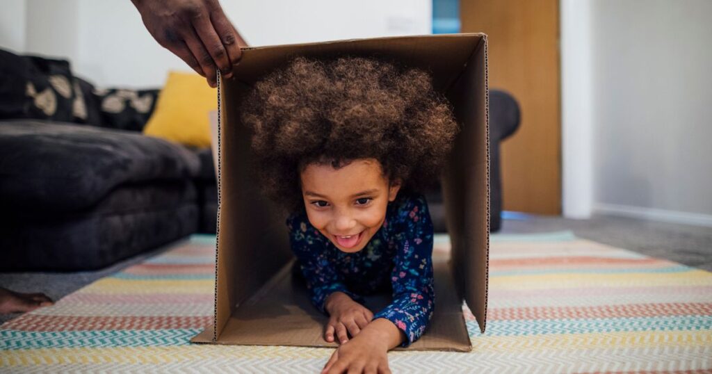 Young kid going through a box in a homemade obstacle course