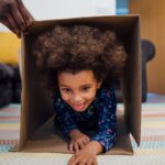 Young kid going through a box in a homemade obstacle course