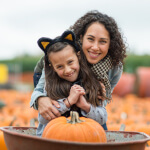 Girl with mom at Pumpkin patch.